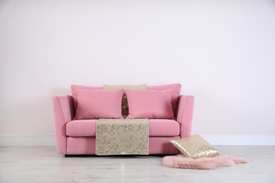 Photo of Stylish pink sofa against white wall in modern living room interior. Space for text