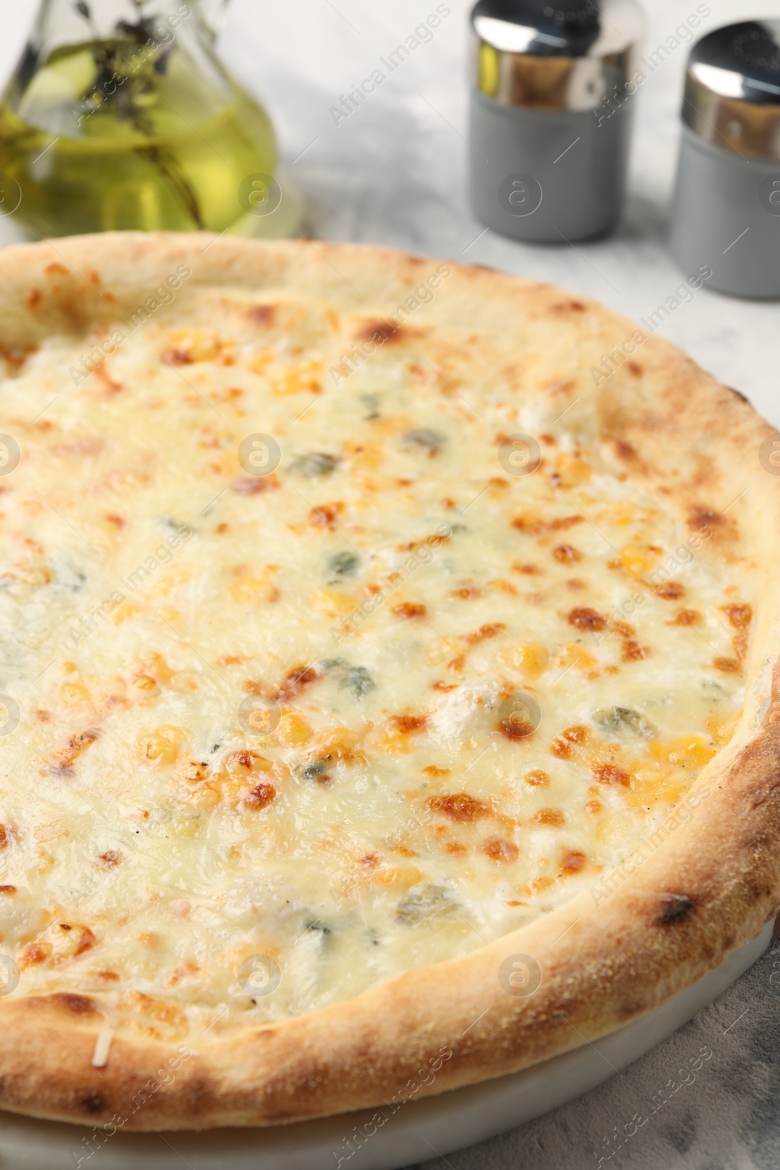 Photo of Delicious cheese pizza and oil on table, closeup