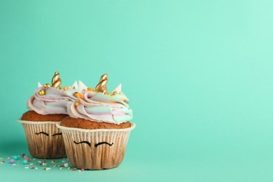 Photo of Cute sweet unicorn cupcakes on turquoise background, space for text