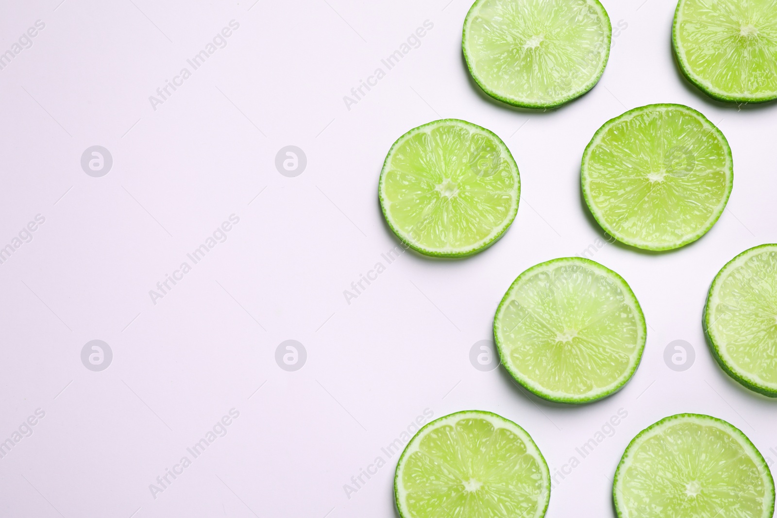 Photo of Juicy fresh lime slices on white background, top view