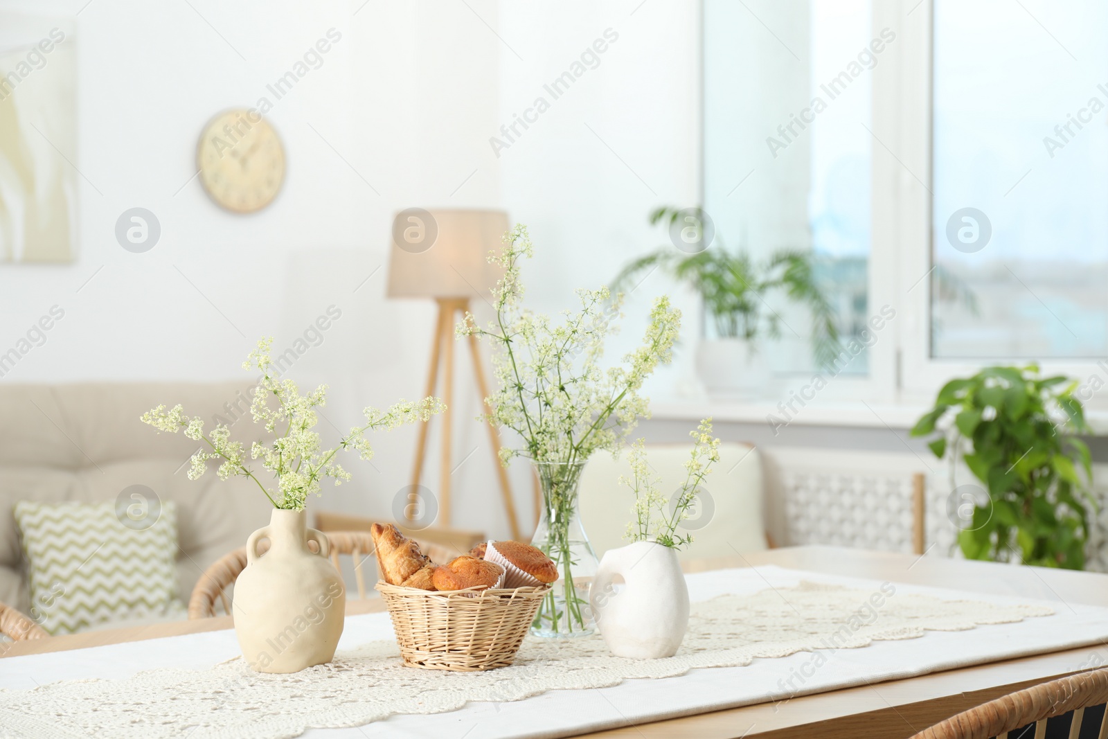 Photo of Fresh pastries and beautiful flowers on table in stylish dining room