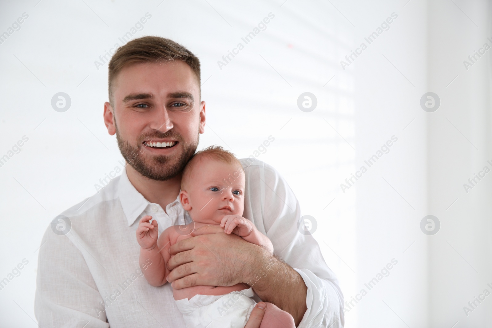 Photo of Father with his newborn son on light background. Space for text