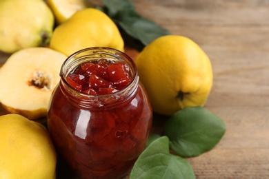 Photo of Delicious quince jam and fruits on table, closeup