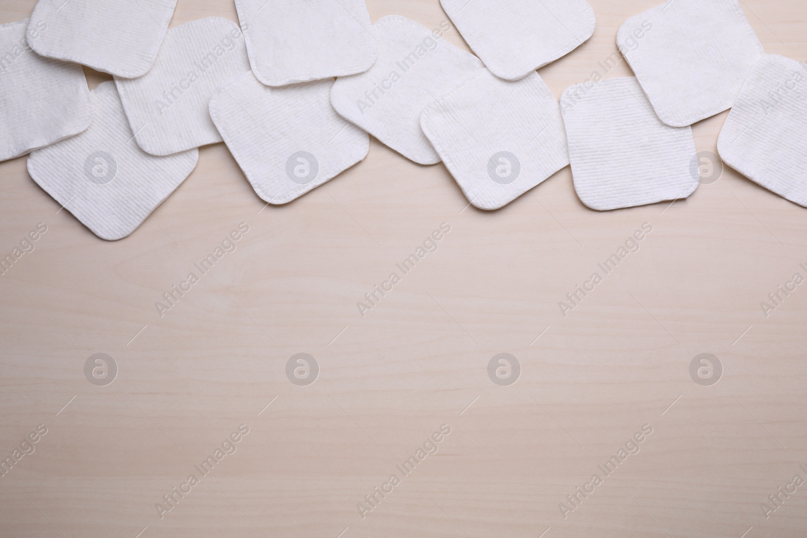 Photo of Many clean cotton pads on wooden table, flat lay. Space for text