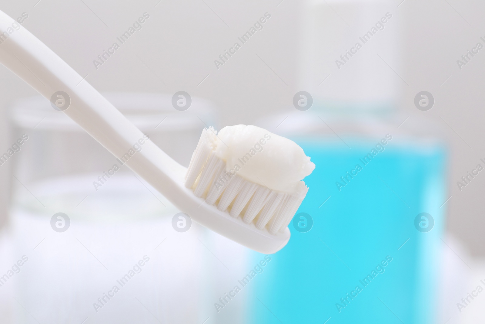 Photo of Toothbrush with paste on blurred background, closeup