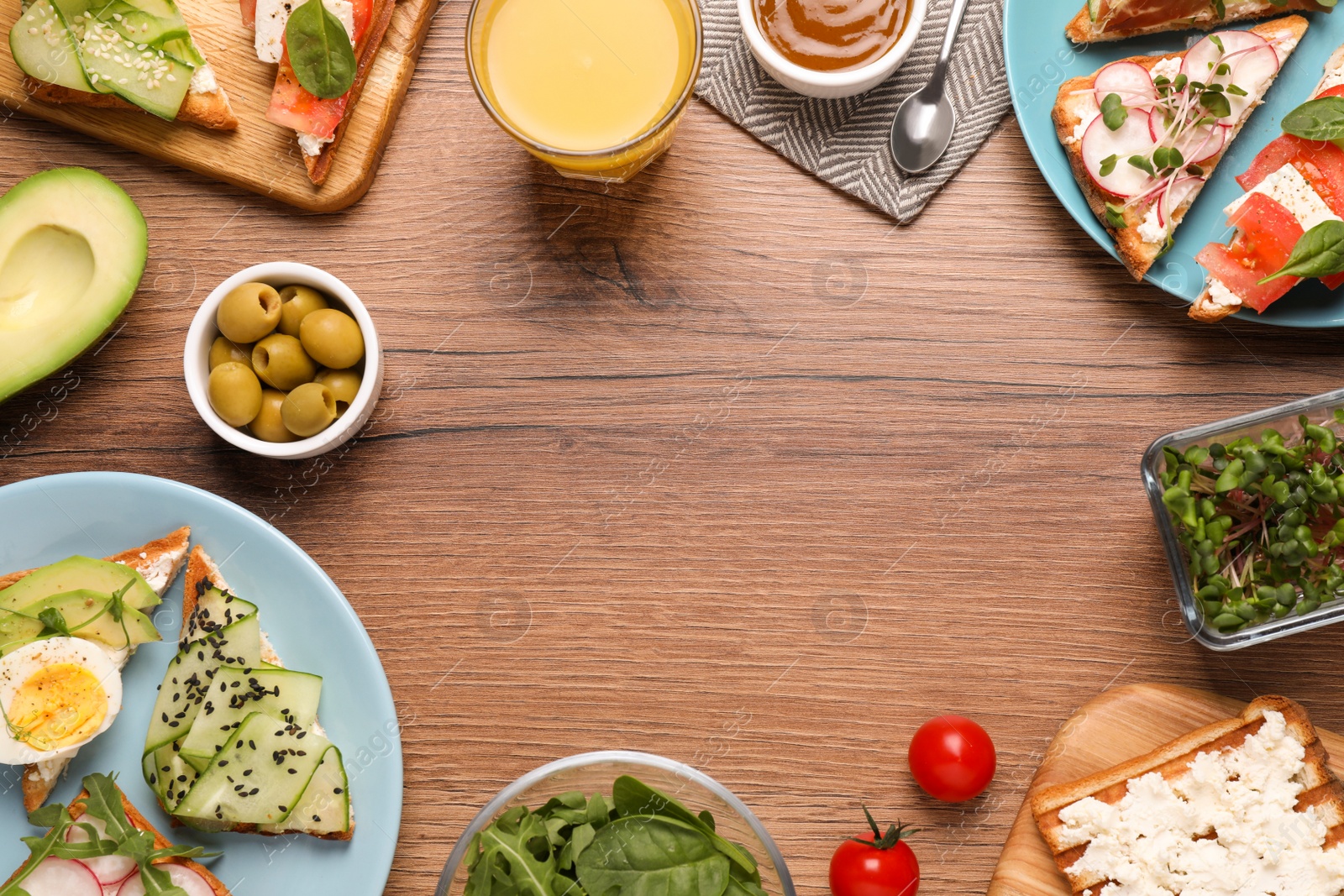 Photo of Tasty breakfast with different sandwiches served on wooden table, flat lay. Space for text