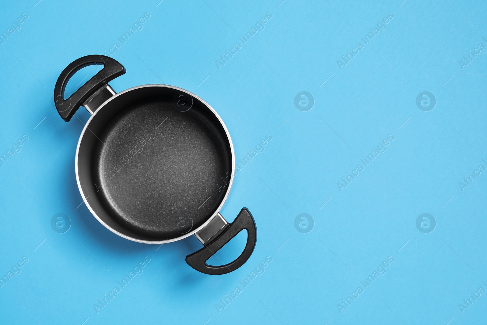 Photo of Empty pot on light blue background, top view. Space for text