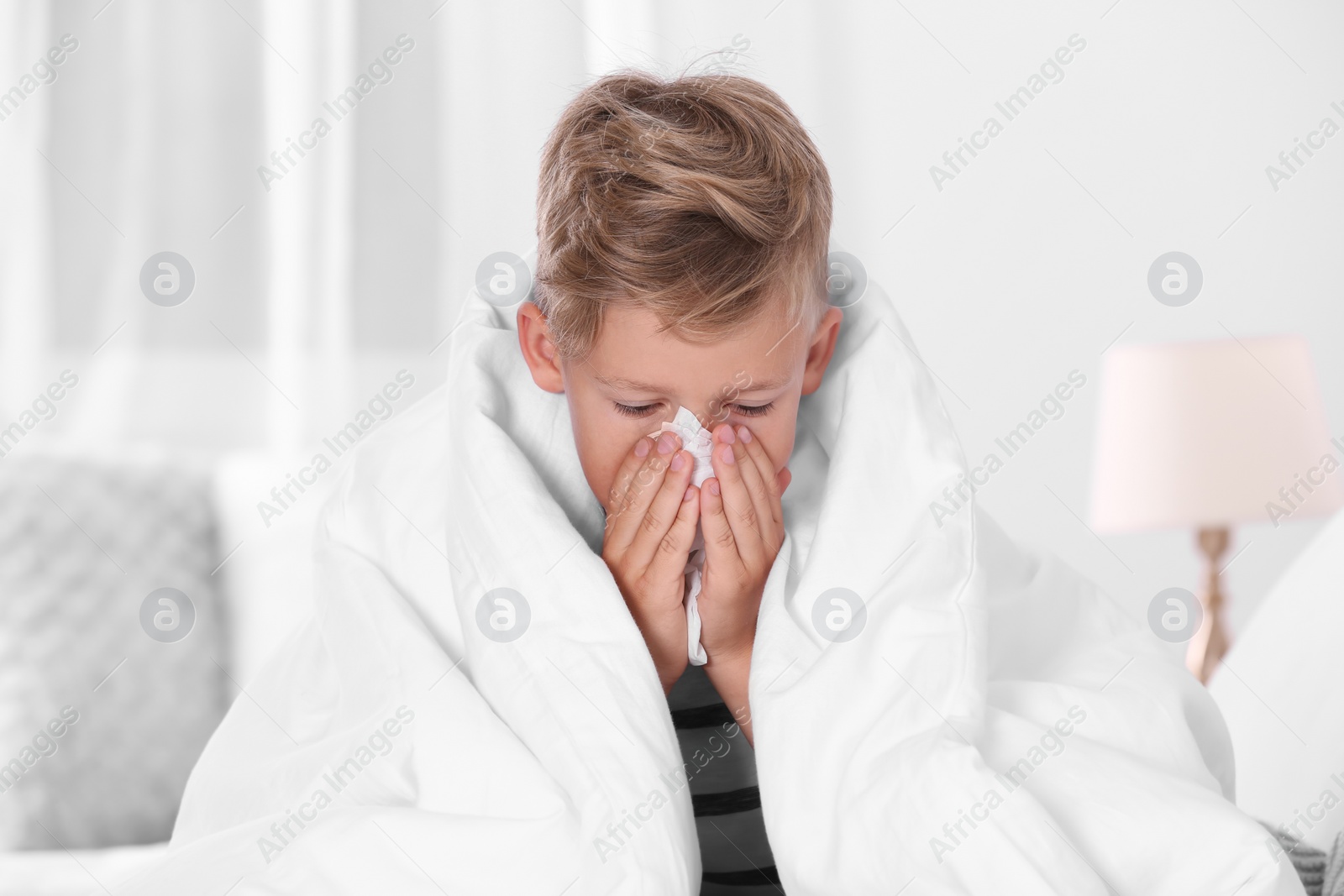 Photo of Ill boy suffering from cough at home