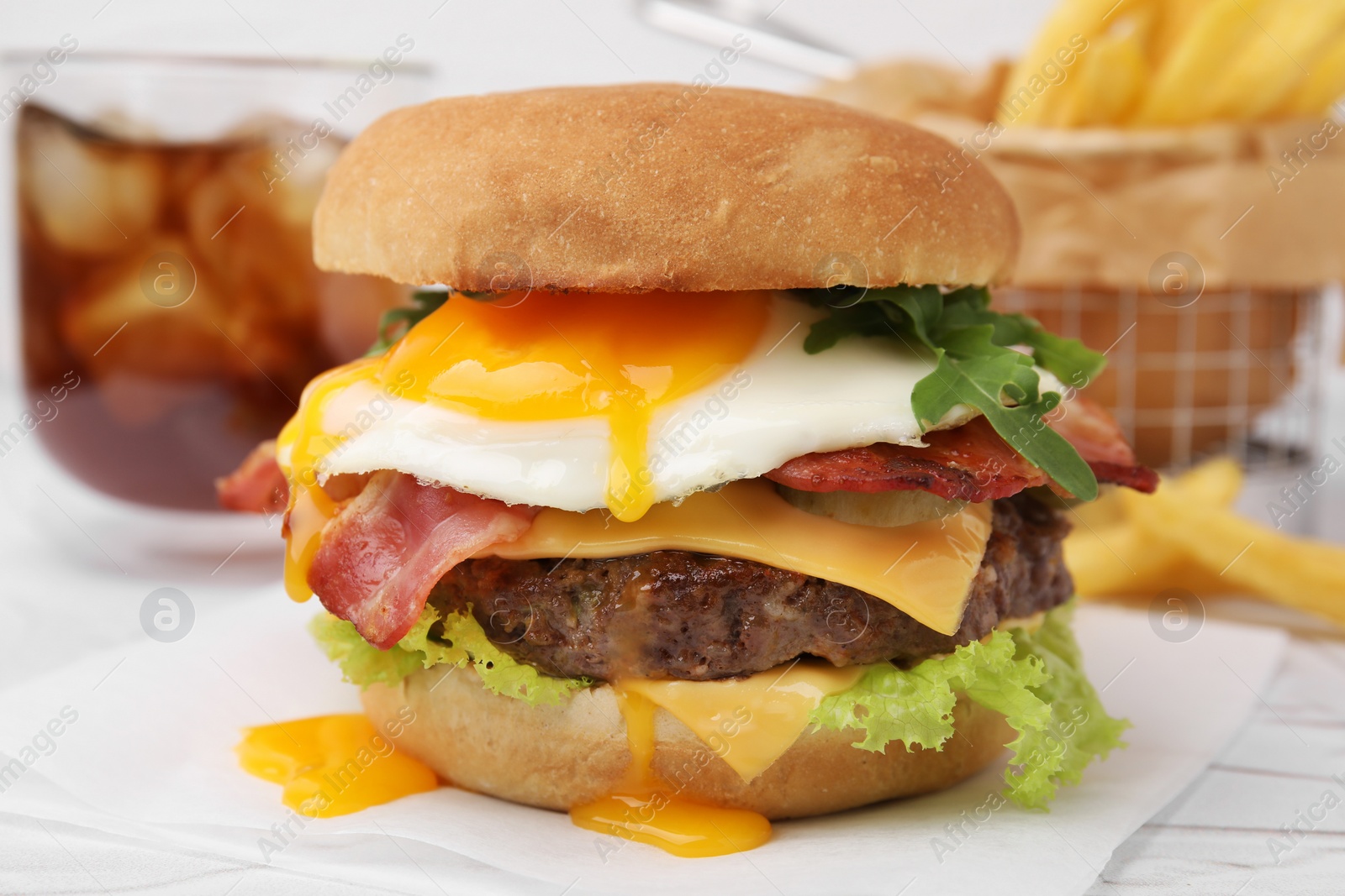 Photo of Delicious burger with fried egg on white table, closeup