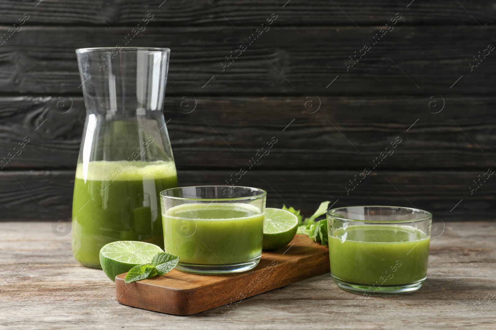 Photo of Glassware with delicious detox juice and ingredients on table