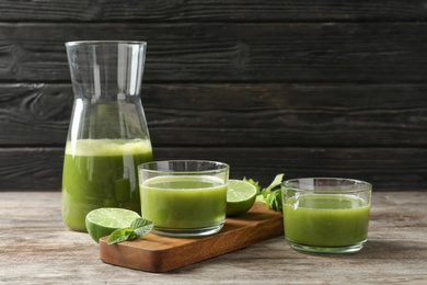 Glassware with delicious detox juice and ingredients on table