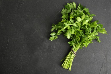 Photo of Fresh green parsley and space for text on black background, top view