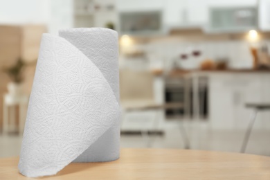 Roll of paper towels on table in kitchen, space for text