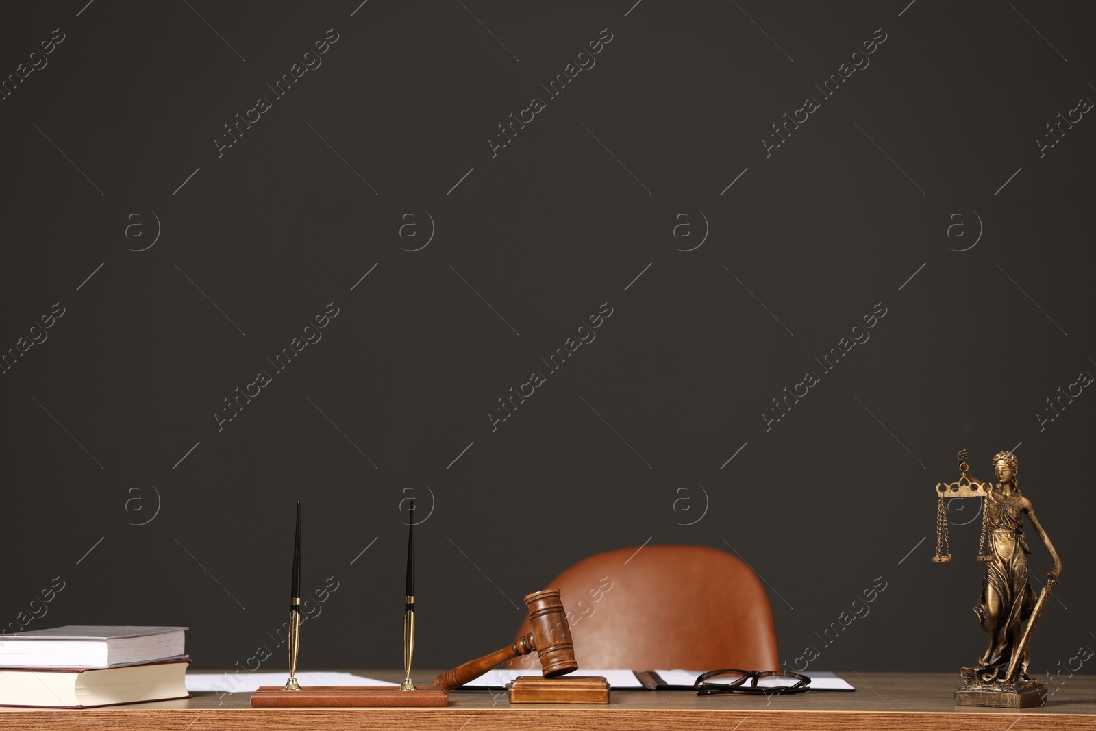 Photo of Judge's workplace with documents, table, chair and mallet. Space for text