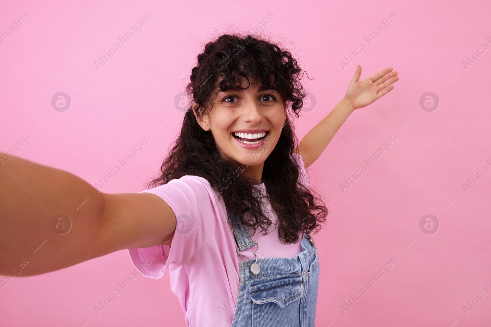 Photo of Beautiful woman taking selfie on pink background