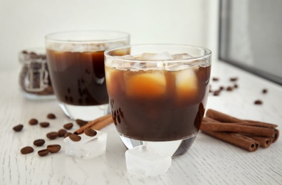 Glasses of coffee drink with ice cubes on table