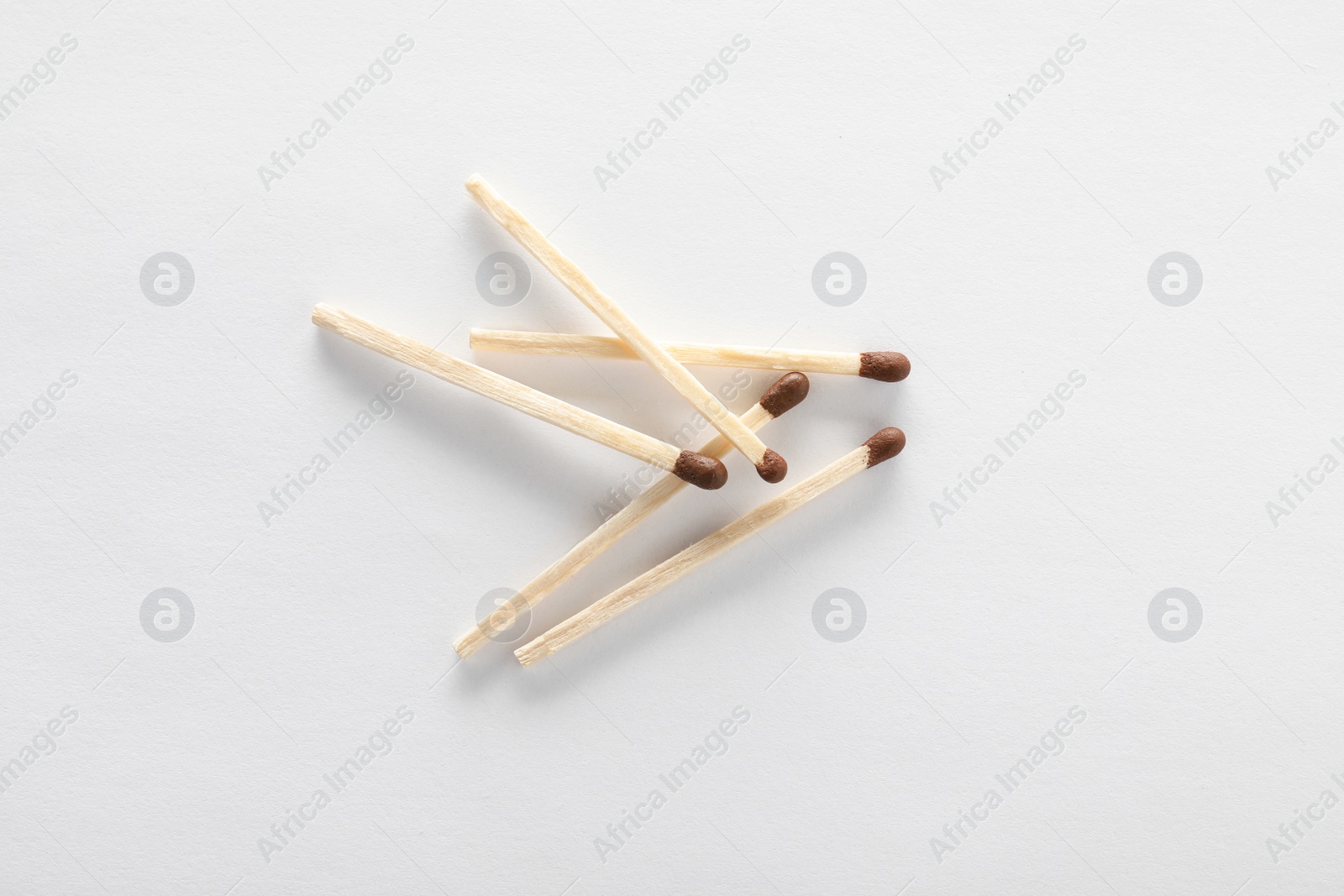 Photo of Wooden matches on white background, top view