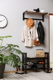 Photo of Hallway interior with stylish furniture, clothes and accessories