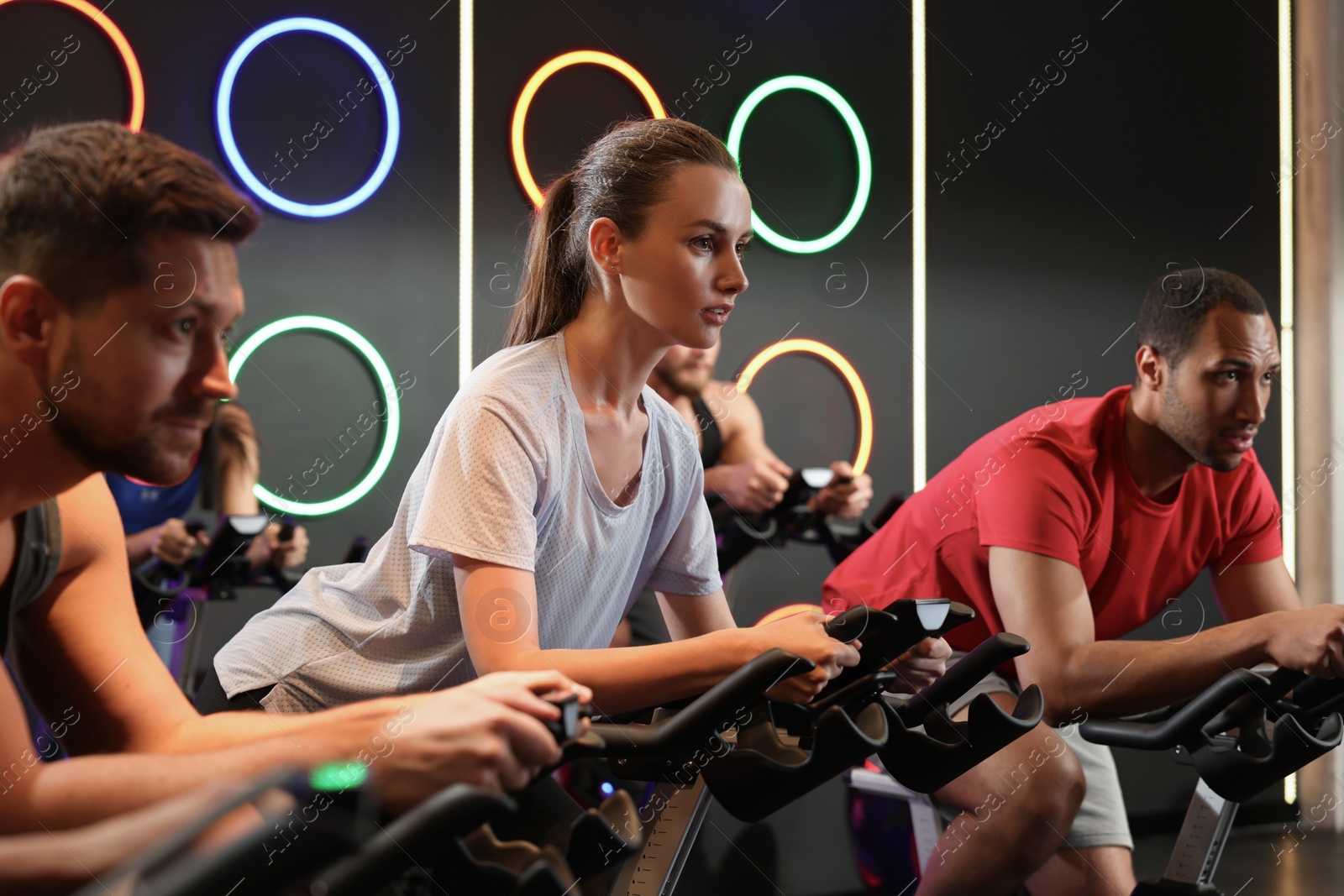 Photo of Group of people training on exercise bikes in fitness club