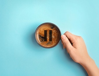 Image of Coffee Break. Woman with cup of americano on turquoise background, top view