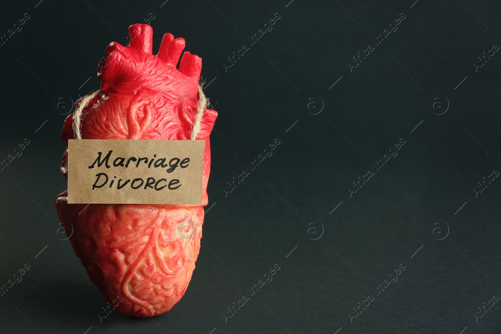 Photo of Model of heart and card with words Marriage Divorce on black background. Space for text