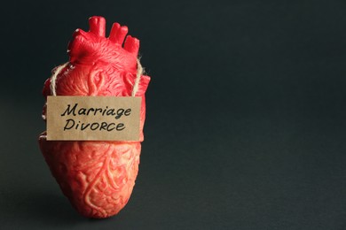 Photo of Model of heart and card with words Marriage Divorce on black background. Space for text