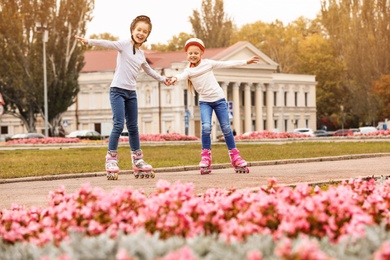 Happy children roller skating on city street