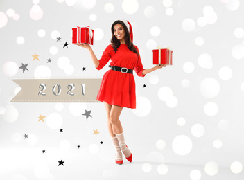 Beautiful woman wearing Christmas costume with gifts on white background. Bokeh effect