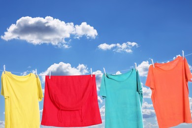 Image of Different clothes drying on washing line against sky