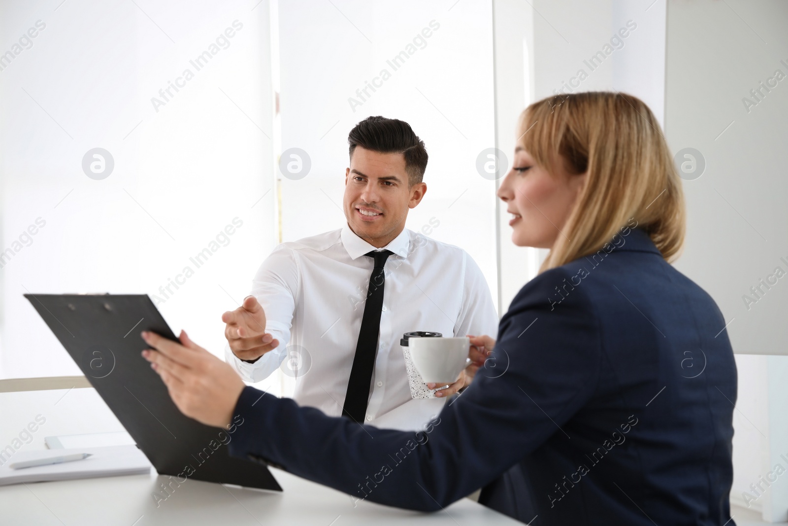 Photo of Office employees talking at table during meeting