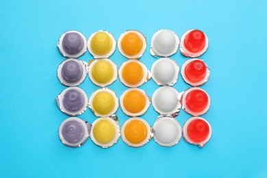 Photo of Tasty bright jelly cups on light blue background, flat lay