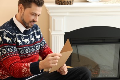 Happy man reading greeting card in living room