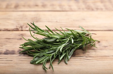 Photo of Sprigs of fresh rosemary on wooden table