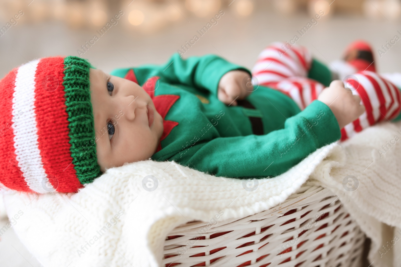 Photo of Cute baby wearing Christmas costume lying in basket at home