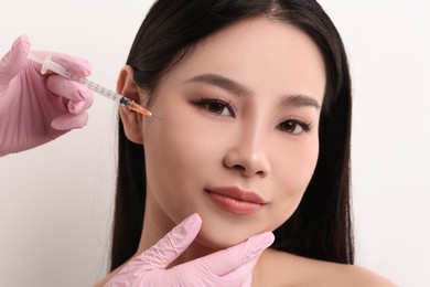 Photo of Woman getting facial injection on white background