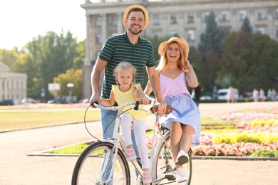 Photo of Happy family with bicycle outdoors on summer day