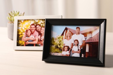 Photo of Frames with family photos on white wooden table indoors