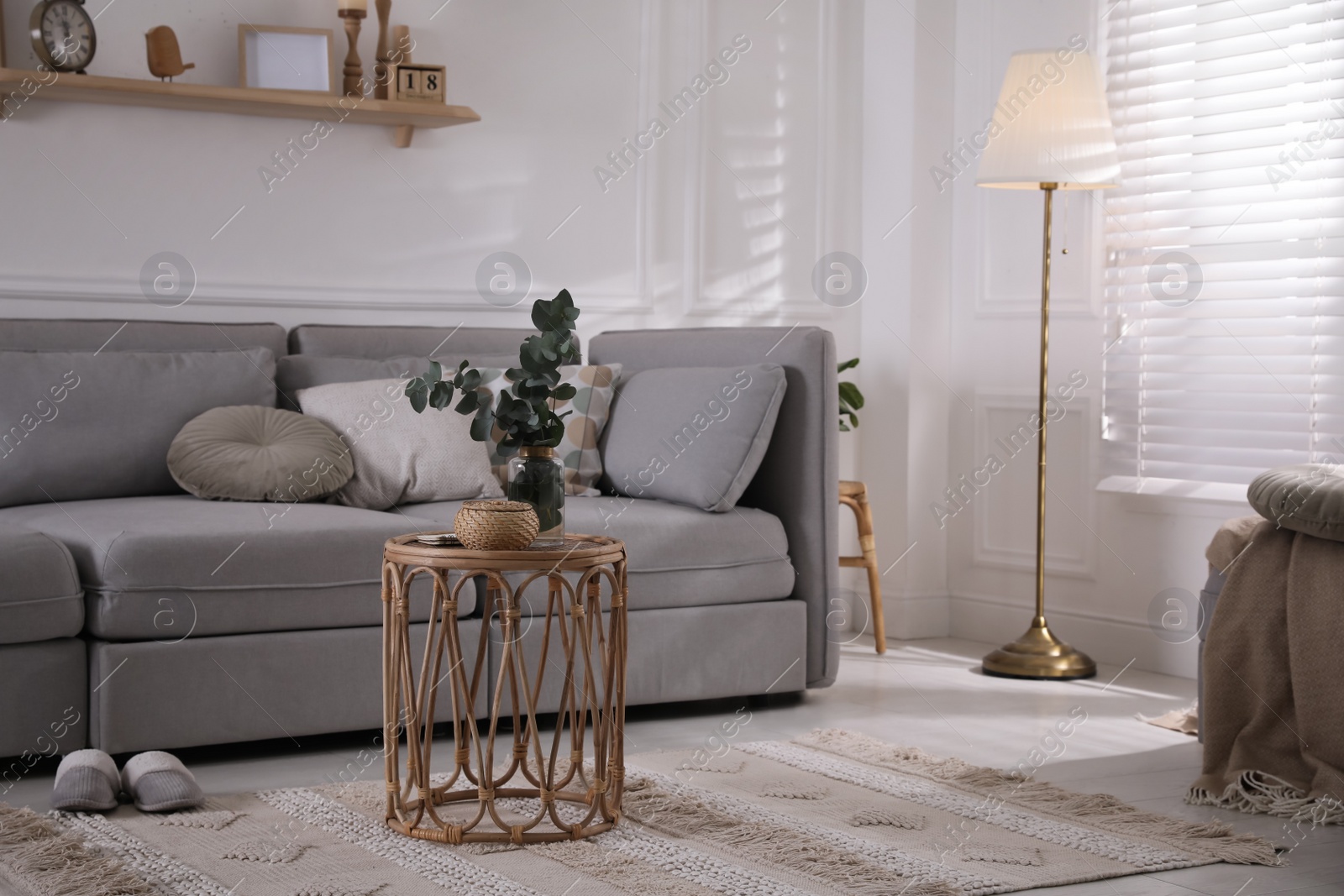 Photo of Living room with comfortable grey sofa and stylish interior elements near window