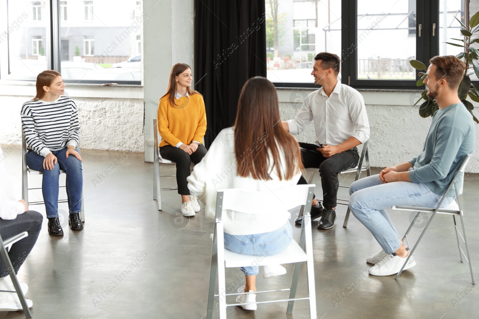 Photo of Psychotherapist working with patients in group therapy session indoors