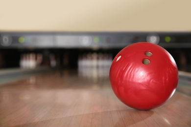 Photo of Red ball on bowling lane in club. Space for text