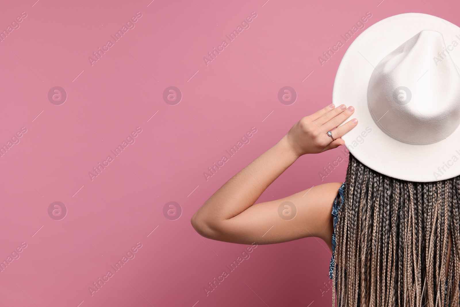 Photo of Woman with african braids on pink background, back view. Space for text