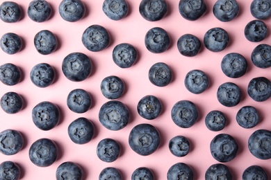 Photo of Tasty ripe blueberries on pink background, flat lay