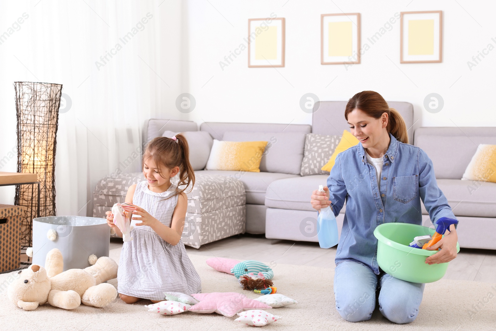 Photo of Housewife and daughter cleaning room together