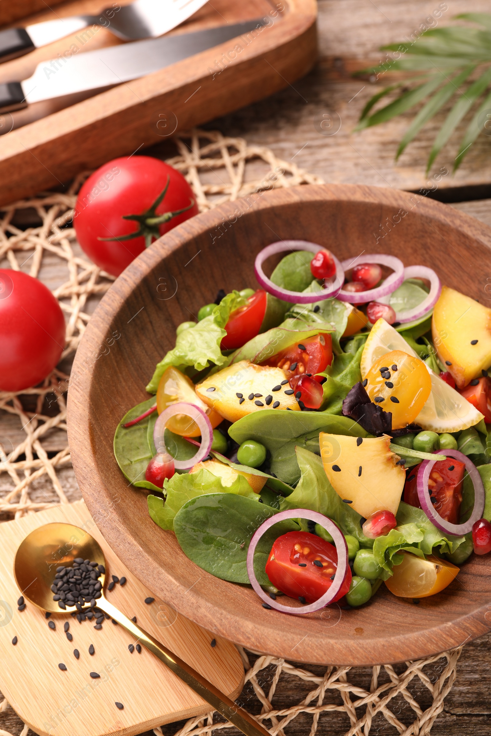 Photo of Delicious salad with peach, green peas and vegetables served on wooden table, above view