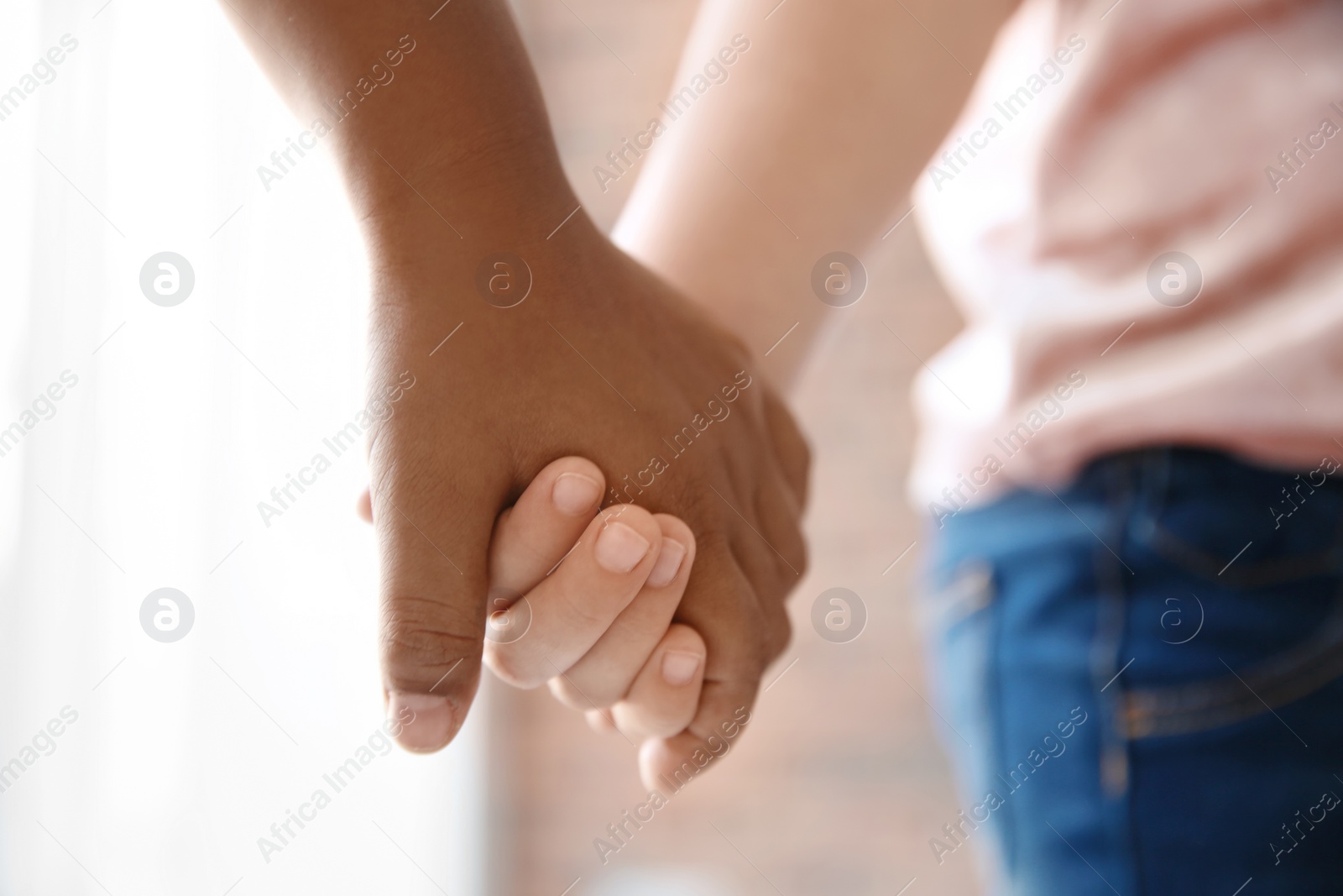 Photo of Children holding hands on blurred background, closeup. Unity concept