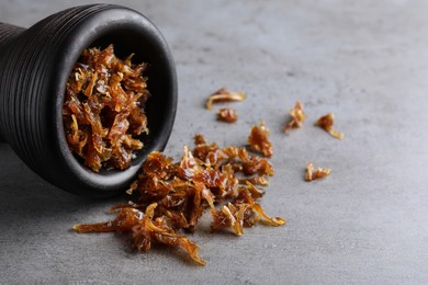 Photo of Modern hookah bowl with tobacco on grey table, closeup. Space for text