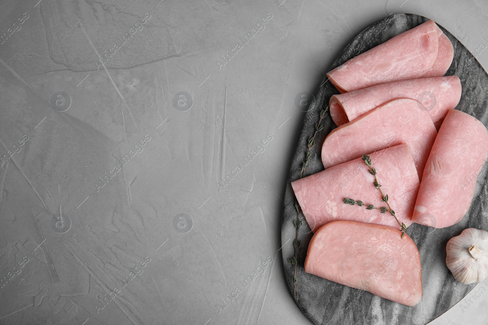 Photo of Tasty ham served on light grey table, top view. Space for text