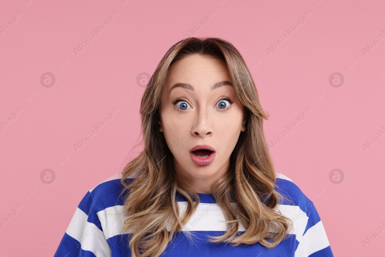 Photo of Portrait of surprised woman on pink background