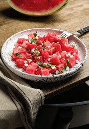 Photo of Delicious salad with watermelon served on wooden table