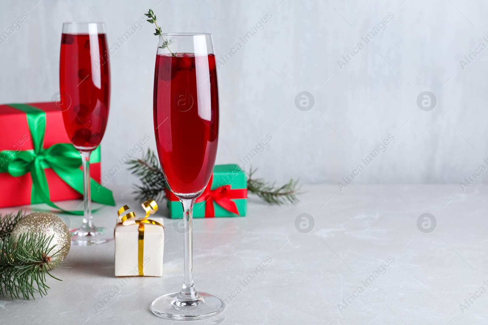 Photo of Delicious Christmas cocktail with liqueur on light table. Space for text